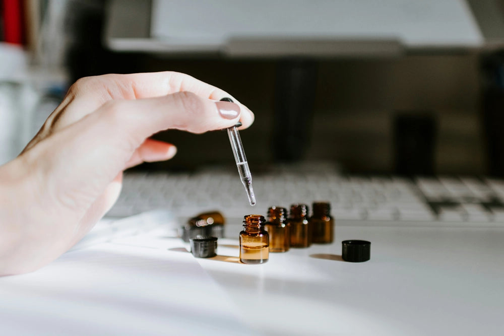 Hand mit flaschen und pipette im Labor